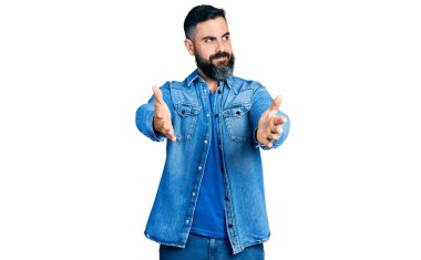 Kolları açık İspanyol bir adam sarılma hareketi yapıyor. Gülümsüyor ve başka tarafa bakıyor.. 