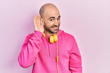 Spor kıyafetleri giyen ve kulaklık takan genç kel bir adam. Kulaktan kulağa gülümseyen. Dedikoduları ve dedikoduları dinliyor. Sağırlık kavramı. 