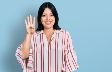 Latin kökenli genç bir kız günlük kıyafetler giyer ve parmaklarıyla dört numarayı gösterir.. 