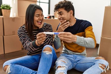 Genç Latin çift yeni evlerinde yerde otururken hamilelik testi yaparken şaşırdılar..