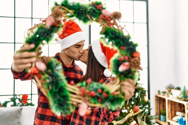 Young Latin Couple Kissing Holding Christmas Decor Home — Zdjęcie stockowe