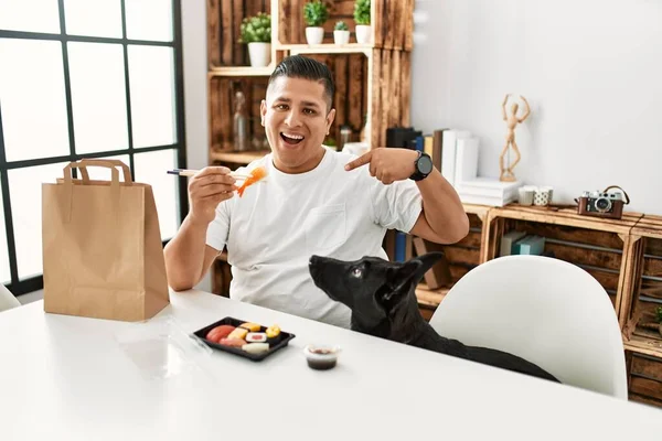 Junger Hispanischer Mann Isst Sushi Mit Essstäbchen Und Zeigt Mit — Stockfoto