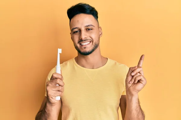 Jeune Homme Arabe Tenant Une Brosse Dents Électrique Souriant Heureux — Photo