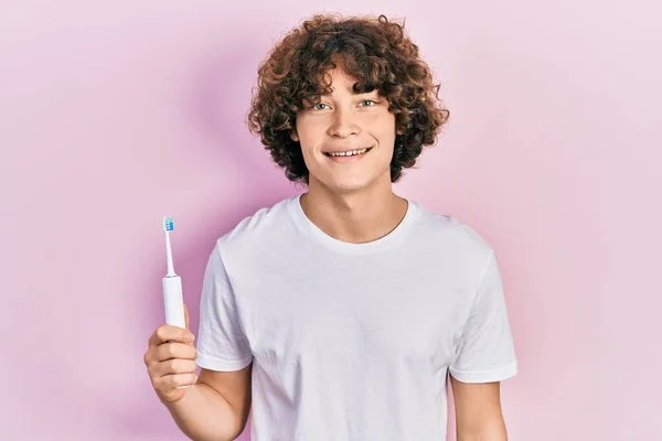 Bonito Jovem Segurando Escova Dentes Elétrica Olhando Positivo Feliz Sorrindo — Fotografia de Stock