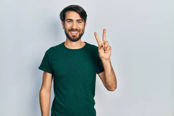 Fiatal Spanyol Férfi Alkalmi Fehér Pólóban Mutatva Mutatva Második Ujjal — Stock Fotó