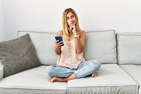 Sarışın Güzel Genç Bir Kadın Evinde Kanepede Oturuyor Akıllı Telefon — Stok fotoğraf