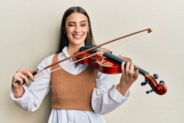 Güzel esmer, genç bir kadın keman çalıyor. Kameraya bakıyor. Seksi bir ifadeyle, neşeli ve mutlu bir yüzle.. 