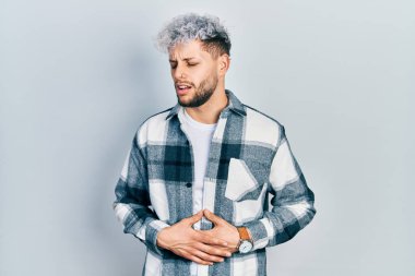 Modern boyalı saçlı, elleri göbeğinde rahat gömlekler giyen genç İspanyol bir adam. Çünkü mide bulantısı, acı verici bir hastalık kendini iyi hissetmiyor. Ağrı kavramı. 