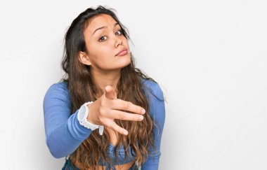 Gündelik kıyafetler giyen genç İspanyol kız kameraya kızgın ve sinirli bir şekilde seni işaret ediyor. 