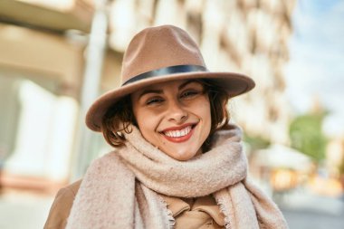 Şık giyinen genç İspanyol kadın şehirde dikiliyor..