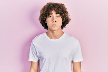 Sıradan beyaz tişörtler giyen yakışıklı genç adam komik yüzlü yanakları şişiriyor. Havayla şişmiş ağız, çılgın bir ifade.. 