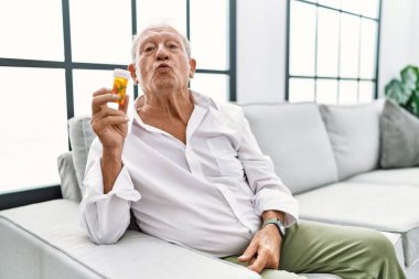 Son sınıf öğrencisi elinde haplarla kameraya bakıyor. Canlı yayında öpücük yolluyor. Sevimli ve seksi. aşk ifadesi. 