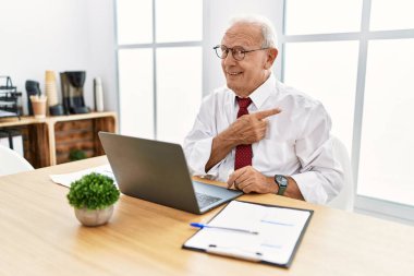 Ofiste çalışan kıdemli bir adam bilgisayarla işaret ediyor endişeli, endişeli ve şaşırmış ifadesini gösteriyor. 