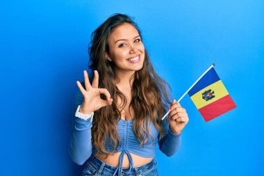 Moldova bayrağı tutan genç İspanyol kız parmaklarıyla imza atıyor, gülümseyerek mükemmel bir sembol oluşturuyor. 