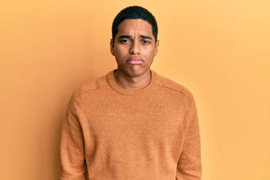 Gündelik kazak giyen genç, yakışıklı İspanyol adam üzgün ve endişeli, sinirli ve korkmuş. hüzünlü ifade. 