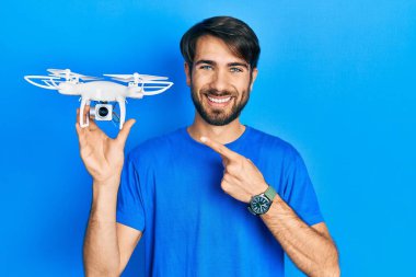 İHA 'yı tutan genç İspanyol adam gülümsüyor. 
