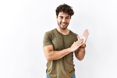 Hispanik adam izole edilmiş beyaz arka planda ayakta alkışlıyor ve mutlu ve neşeli, gururlu elleri bir arada alkışlıyor. 