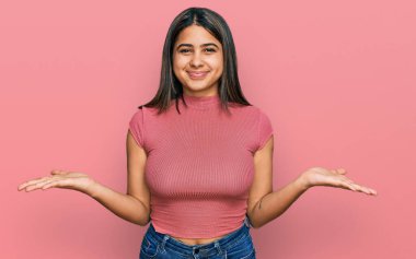 Sıradan tişörtler giyen, elleri ve kolları havada, kafası karışık genç İspanyol kız. şüphe kavramı. 