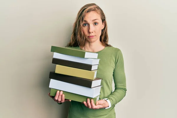 Mujer Rubia Joven Sosteniendo Montón Libros Escéptico Nervioso Frunciendo Ceño — Foto de Stock
