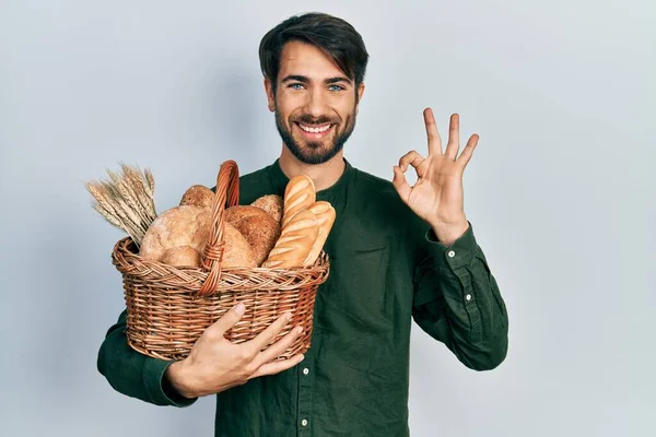 Молодий Іспаномовний Чоловік Тримає Плетений Кошик Хлібом Робить Знак Пальцями — стокове фото