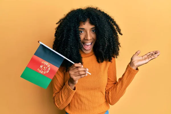 Africká Americká Žena Afro Vlasy Drží Afghánskou Vlajku Slaví Úspěch — Stock fotografie