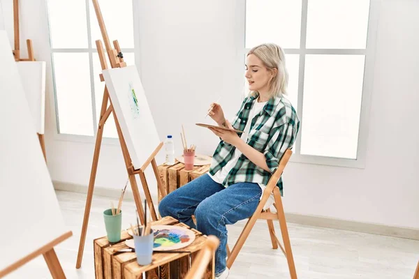 Young artist student girl smiling happy painting at art studio.