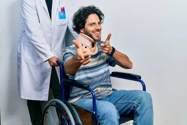 Handsome Hispanic Man Sitting Wheelchair Wearing Neck Collar Pointing Fingers — Stock Photo, Image