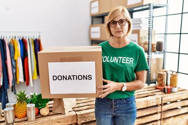 Middelbare Leeftijd Blonde Vrouw Dragen Vrijwilliger Shirt Met Donaties Doos — Stockfoto