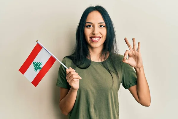 Mladá Hispánka Držící Libanonskou Vlajku Dělá Pořádku Znamení Prsty Usměvavé — Stock fotografie