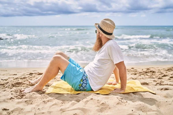 Jovem Ruiva Homem Sorrindo Feliz Sentado Toalha Praia — Fotografia de Stock