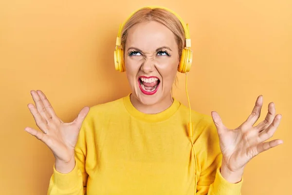 Mujer Rubia Joven Escuchando Música Usando Auriculares Locos Locos Gritando —  Fotos de Stock