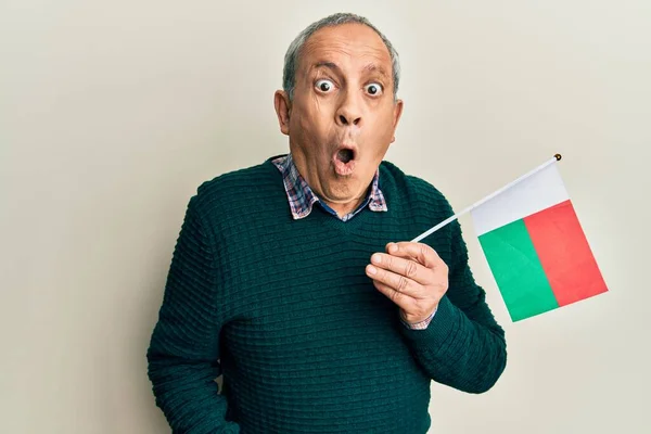Stilig Senior Man Med Grått Hår Håller Madagaskarflagga Rädd Och — Stockfoto