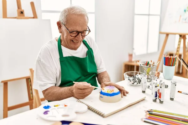 Senior Grauhaarige Künstler Mann Lächelt Glücklich Malerei Keramik Sitzt Auf — Stockfoto