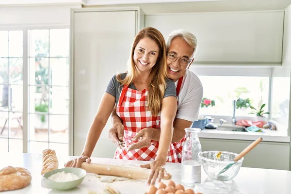 Middelbare Leeftijd Hispanic Paar Glimlachen Gelukkig Knuffelen Kneden Deeg Keuken — Stockfoto