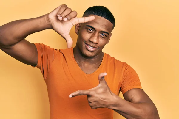 Joven Hombre Negro Con Camiseta Naranja Casual Sonriendo Haciendo Marco —  Fotos de Stock