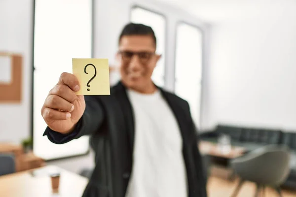 Joven Empresario Latino Sonriendo Feliz Sosteniendo Recordatorio Signo Interrogación Oficina —  Fotos de Stock