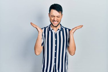 Gündelik kıyafetler giyen genç İspanyol adam başarı için deli ve çılgınlığı kutluyor kollarını kaldırmış ve gözlerini kapatmış heyecanla bağırıyor. Kazanan konsept 