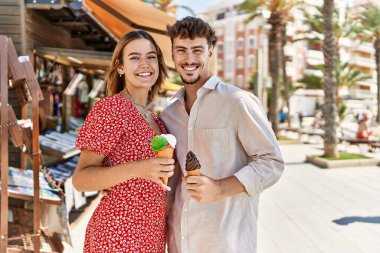 Genç İspanyol çift gülümsüyor, şehirde dondurma yiyorlar..
