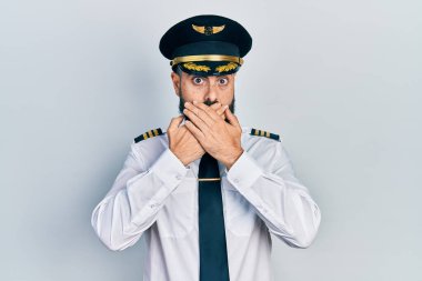 Uçak pilotu üniforması giyen genç bir İspanyol yanlışlıkla ağzı ellerle kapatmış. gizli kavram. 