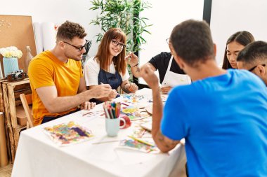 Resim stüdyosunda çizim yapan bir grup insan..