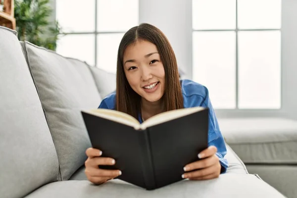 Ung Kinesisk Flicka Läser Bok Liggande Soffan Hemma — Stockfoto