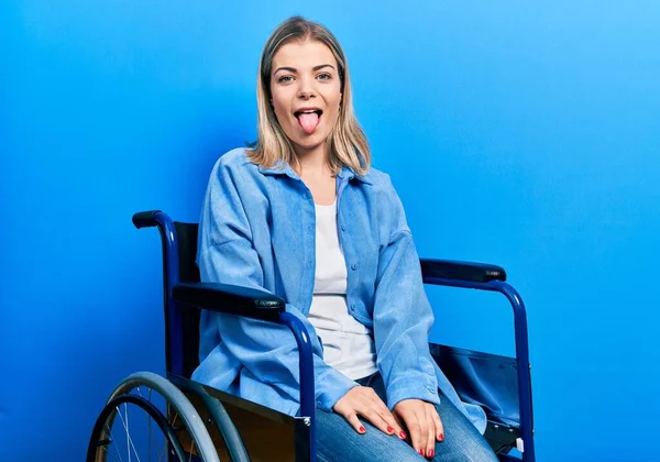 Красивая Белая Женщина Сидящая Инвалидной Коляске Торчащая Языком Довольная Смешным — стоковое фото