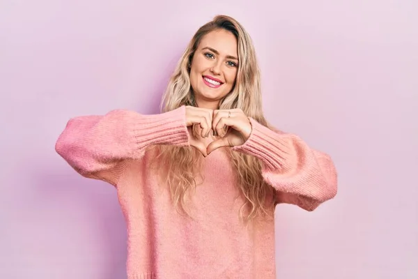 Linda Jovem Loira Vestindo Suéter Rosa Sorrindo Amor Mostrando Símbolo — Fotografia de Stock