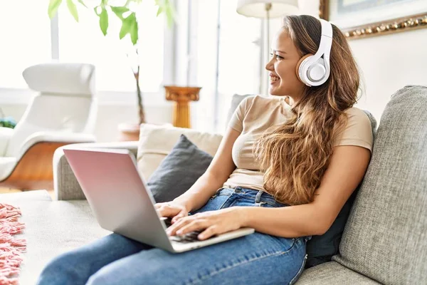 Laptop Kulaklık Kullanan Genç Spanyol Kız Evdeki Koltukta Oturuyor — Stok fotoğraf