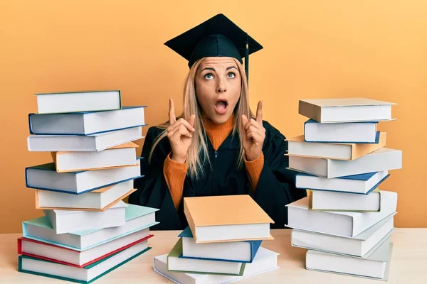 Mujer Joven Caucásica Vestida Con Bata Ceremonia Graduación Sentada Mesa — Foto de Stock