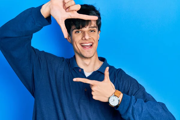 Guapo Hipster Joven Varado Sobre Fondo Azul Sonriendo Haciendo Marco — Foto de Stock