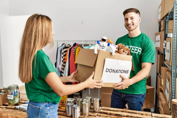 Jong Hispanic Vrijwilliger Paar Glimlachen Gelukkig Holding Box Met Speelgoed — Stockfoto