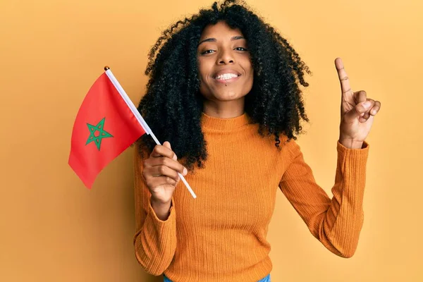 Afroamerykanka Afro Włosy Trzymając Marokańską Flagę Uśmiecha Się Pomysłem Lub — Zdjęcie stockowe