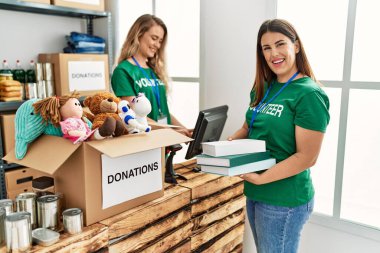 Genç gönüllü kız yardım merkezinde kadına yardım ediyor..