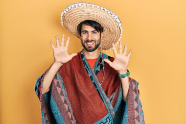 Meksikalı şapkalı İspanyol genç adam on numarayı gösterip işaret ederken kendinden emin ve mutlu gülümsüyor.. 